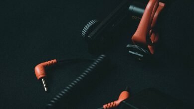 Close-up view of an orange coiled audio cable and adapter on dark background.