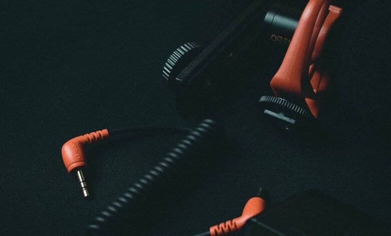 Close-up view of an orange coiled audio cable and adapter on dark background.